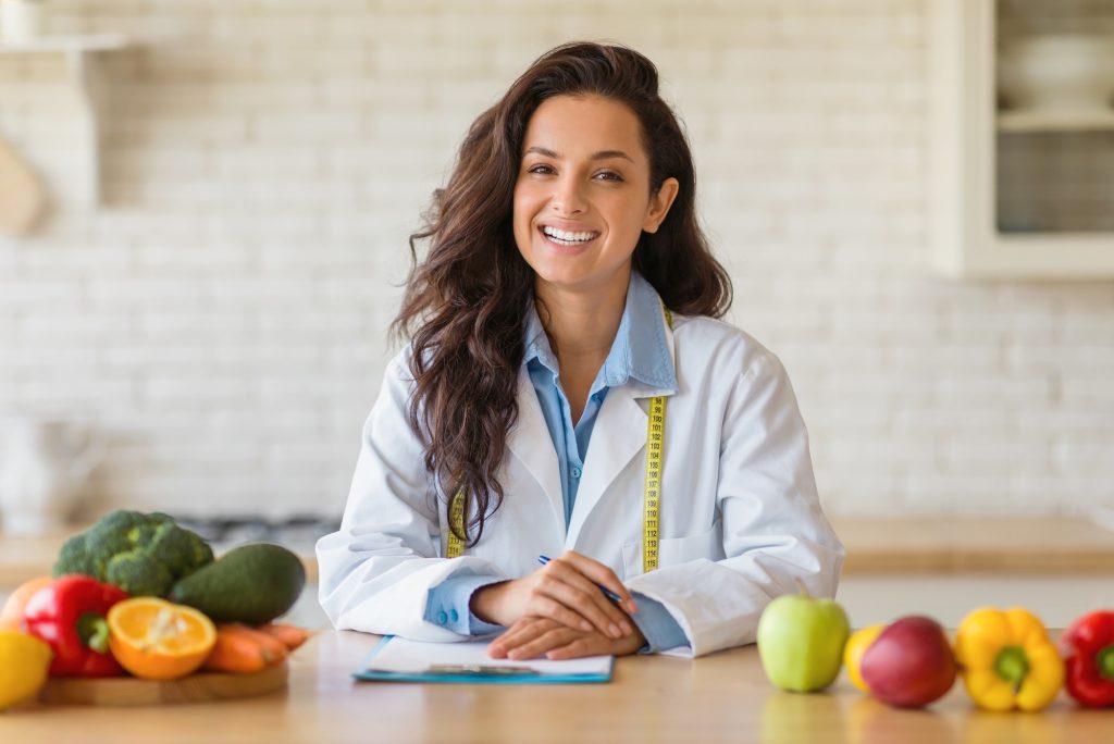Portrait of friendly female weight loss consultant smiling at camera, recommending plant based