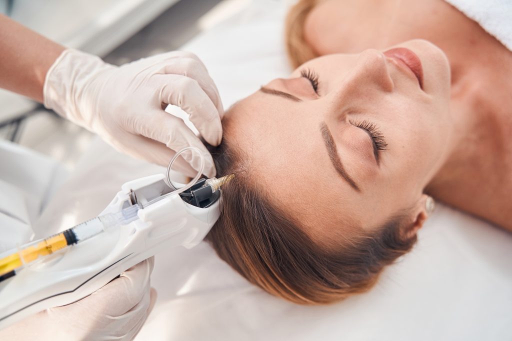 Serene woman during procedure of head mesotherapy
