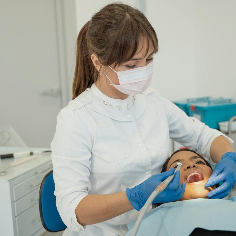 Dentist performing a routine dental check-up on a patient in a modern clinic setting.