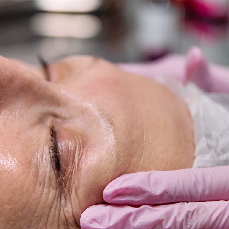 Close-up of a senior woman receiving a relaxing facial treatment in a spa setting.