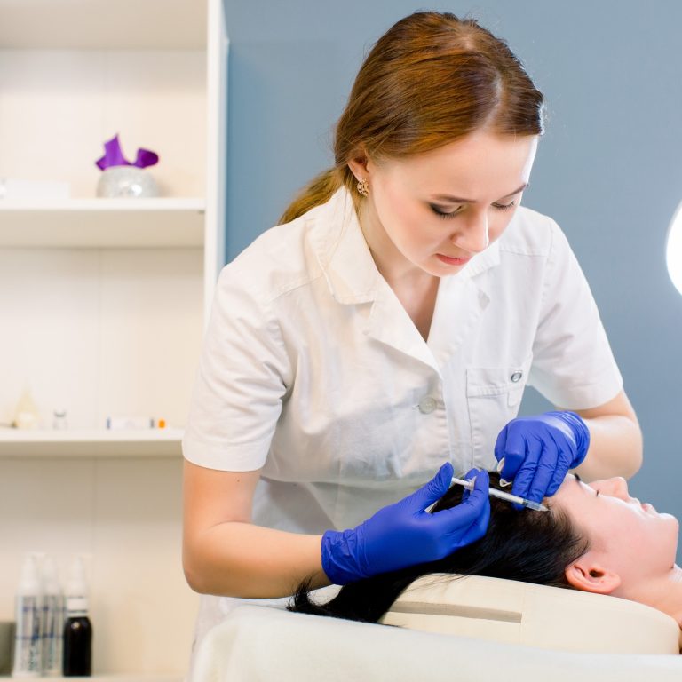 Procedure of hair mesotherapy. Young woman doctor cosmetologist makes the procedure of mesotherapy