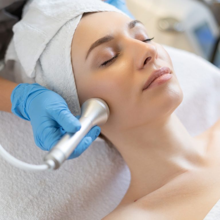 young-woman-lying-cosmetologist-s-table-rejuvenation-procedure-cosmetologist-take-care-about-neck-face-skin-youthfull-wellness-hardware-face-cleaning-procedure (1)